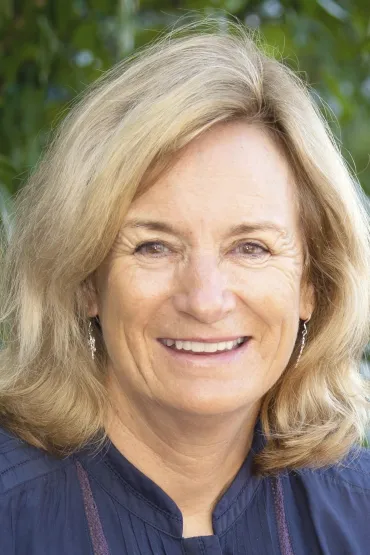 Jenny Davis, head and shoulders, with out of focus green leafy background