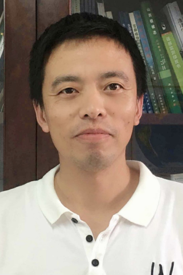 Professor Jian Zhang, head and shoulders, with book case in backround