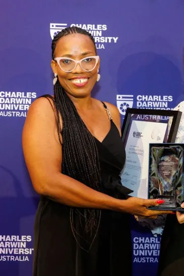 Isabella holds her certificate and trophy