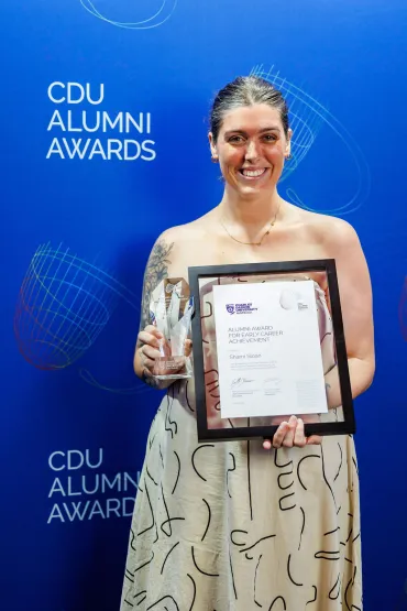 Sharni stands with her award