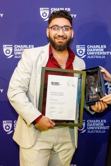 Ali poses for camera with certificate and trophy