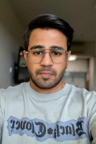 Man standing on stage holding microphone speaks to audience