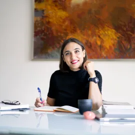 Yulila Shche writing at a desk / working from home